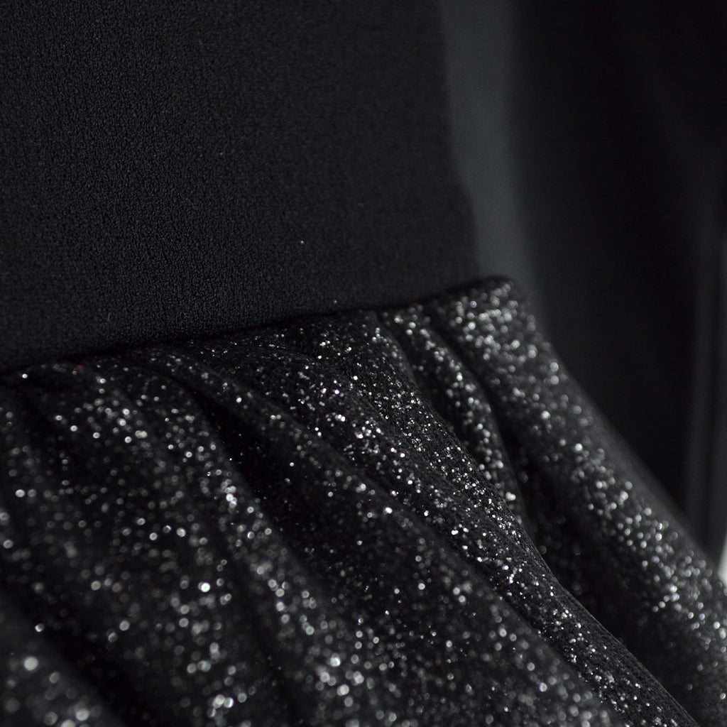 Detalle de la cintura fruncida y la falda de tul negro con destellos brillantes del vestido de esqueleto.