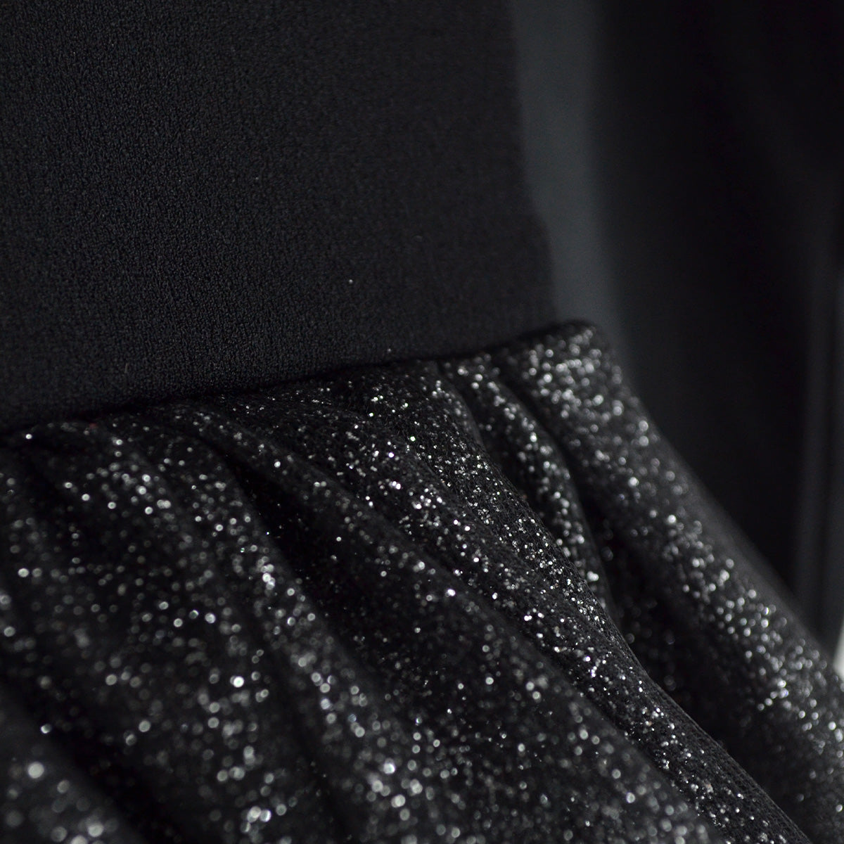 Detalle de la cintura fruncida y la falda de tul negro con destellos brillantes del vestido de esqueleto.