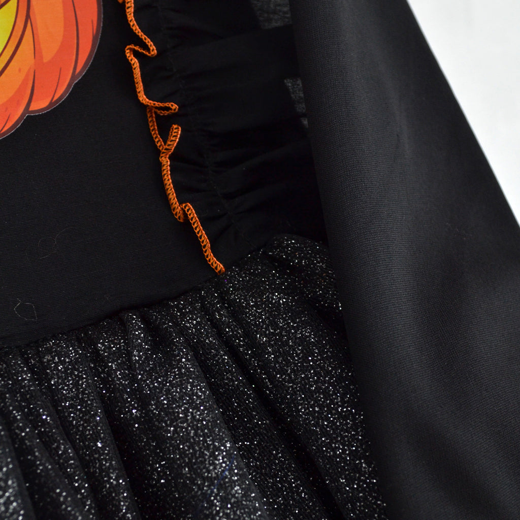 Detalle del vestido negro de calabaza, con volante de ribete naranja y falda de tul brillante.