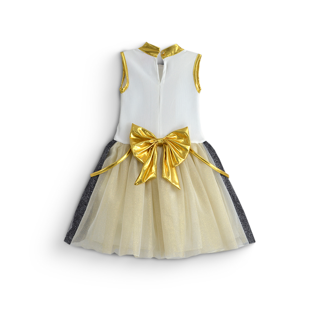 Vestido infantil color marfil sin mangas, con detalles dorados en el cuello y las sisas, un gran moño dorado y falda de tul.