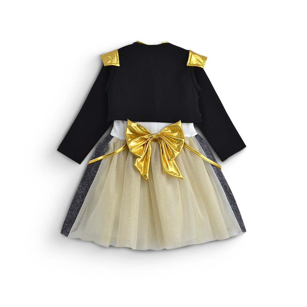 Vista trasera de conjunto infantil con saco negro de manga larga con detalles dorados, falda de tul color marfil y moño dorado.