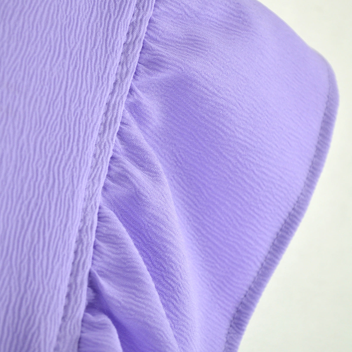 Detalle del bolsillo lateral y la textura de la tela del pantalón infantil lila.