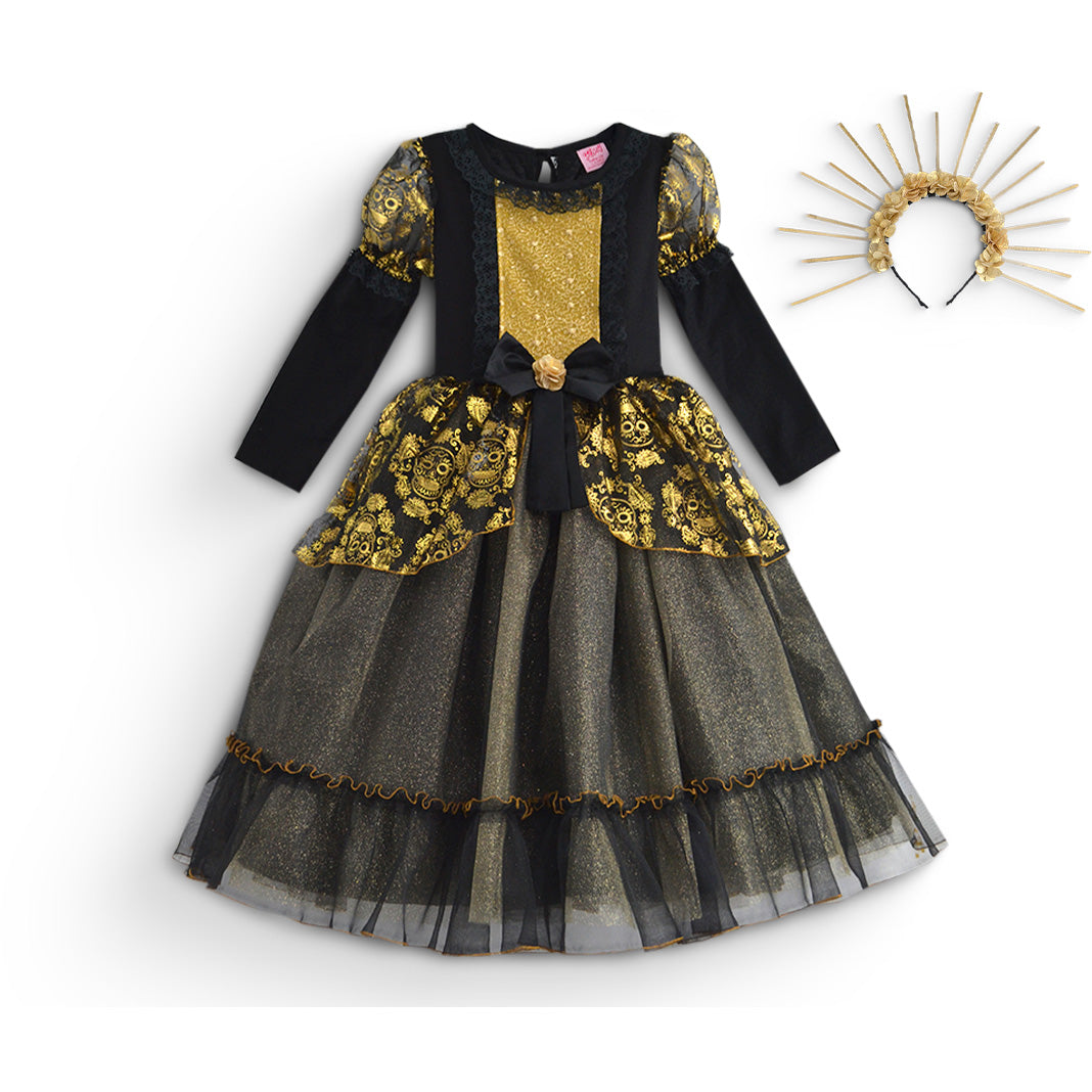 Vestido infantil negro y dorado de manga larga, con estampado de calaveras, lazo en la cintura y falda de tul en capas, junto a una diadema dorada con rayos.